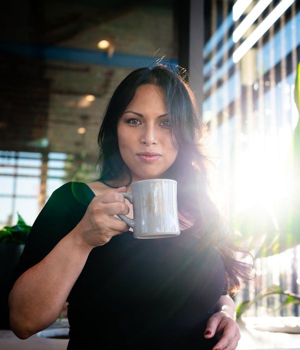 Smiling person looking refreshed and full of energy outdoors in the morning sun.